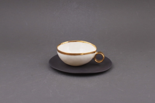 Cieniutka, porcelanowa filiżanka na czarnym spodku
